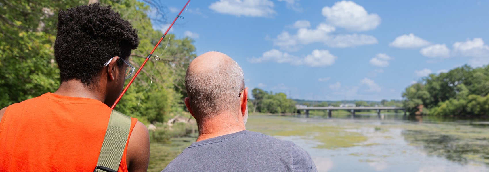 Foster dad and foster child fishing on a sunny day.